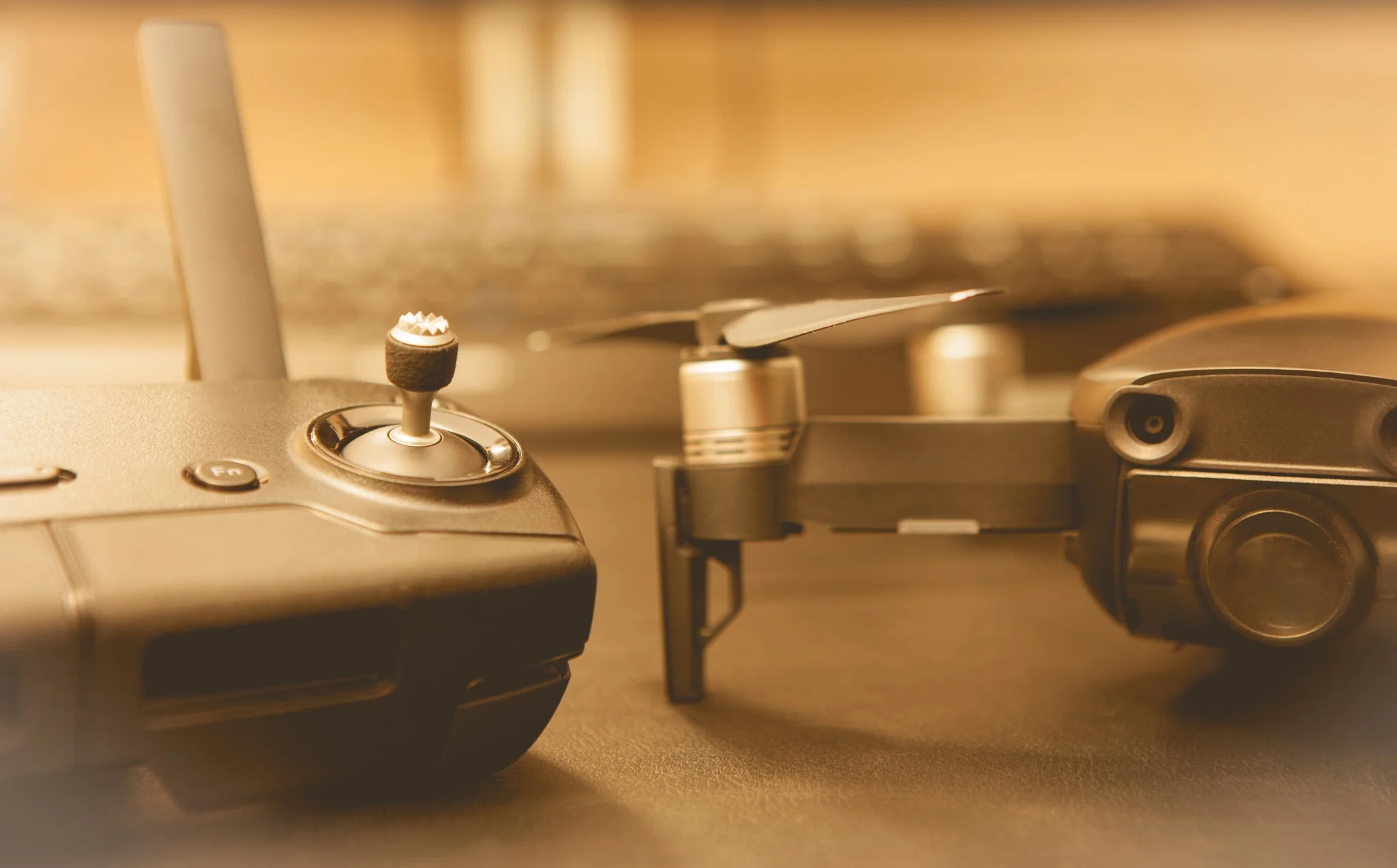 Close-up of a handheld quadcopter drone controller in warm light