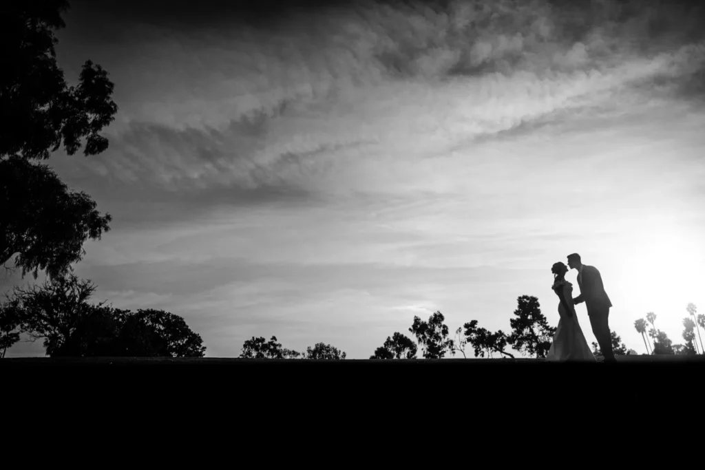 A silhouette of a bride and groom about to kiss in a field by Antoine Didienne.