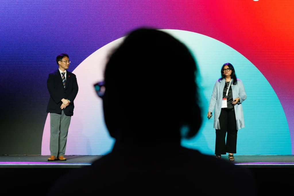 An image of two speakers on stage at an event by Aleksandra Dynaś