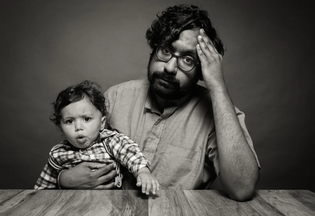 A photograph of a father sitting with his toddler at a table by Antoine Didienne.